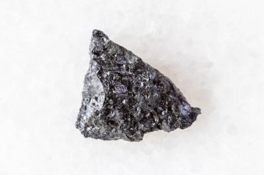 sample of raw hulsite mineral on white marble background close up from Yakutia, Russia