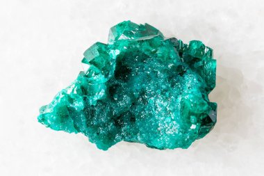 sample of raw dioptase mineral on white marble background close up from Kazakhstan