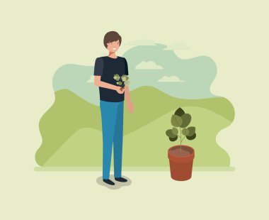 Genç adam parkta ağaç dikme