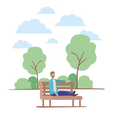 sakallı genç adam parkta sandalyede oturuyor