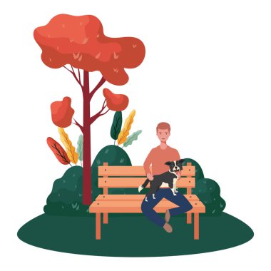 Genç adam parkta sevimli bir köpeği kaldırıyor.