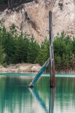 Parlak mavi suyla gölde boğulmuş eski ahşap elektrikli sütun