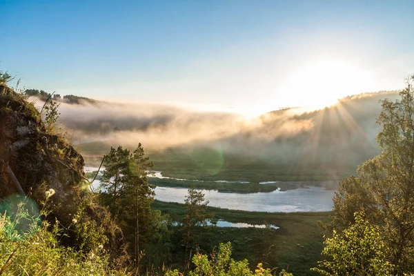 Rays of sun above mountain river in the morning