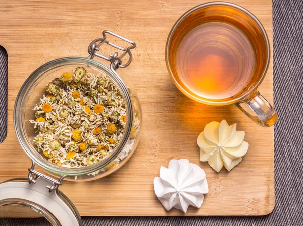 Still life with healthful herbal tea, sweets and wooden cutting board