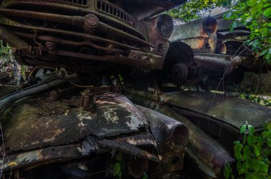 paslı arabalardan birbirinin üzerinde bir araba mezarlığı