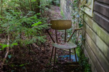 Terk edilmiş bir evin yanındaki eski koltuk