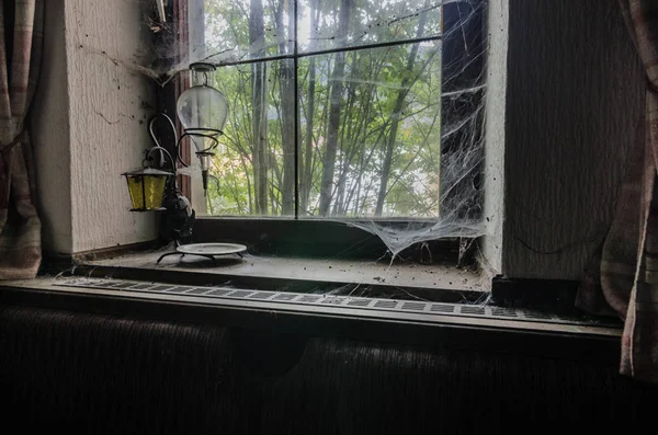 Lâmpada em um peitoril da janela com teias de aranha — Fotografia de Stock