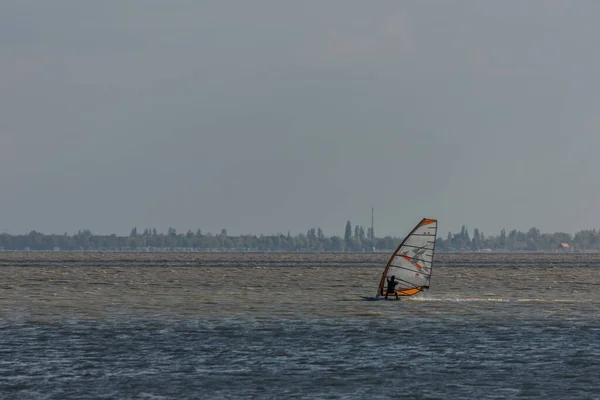 Arka Planda Manzarası Olan Güçlü Rüzgarla Rüzgar Sörfü Yapmak — Stok fotoğraf