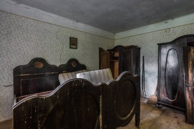 Koyu kahverengi odundan yapılmış yatak ve dolaplar.