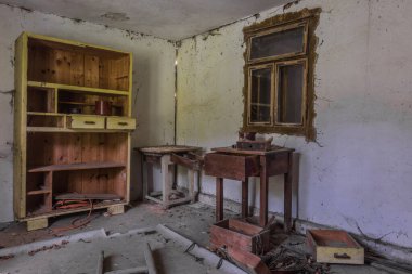 Odasında ahşaptan yapılmış bir dolap ve bir evin penceresi var.