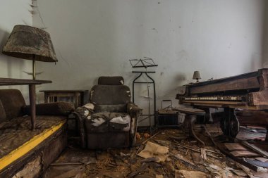 Sandalye lambası ve piyano eski bir evin odasında.