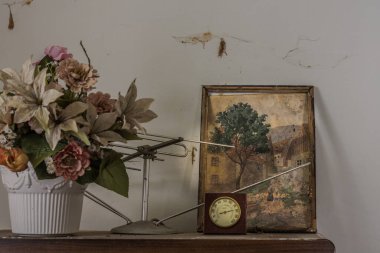 Eski bir evdeki plastik resimler ve çiçekler.