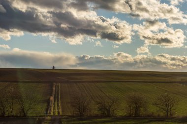 Ufuktaki yol kenarı tapınağında gökyüzünde bulutlar olan bir manzarada
