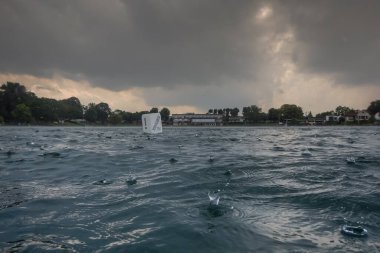 Yazın dalarken yağmurun altında gölde damlalar.