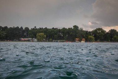 Yazın bir gölde yağmur yağarken büyük damlalar.