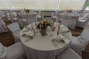 Yuvarlak masalar ve sandalyeler ve düğün sofrası.