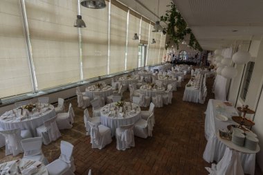 Sarayda bir düğünde yuvarlak masalar ve sandalyeler.