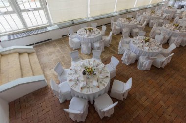 Yuvarlak tablolar ve yukarıdan beyaz dekorasyon görünümü