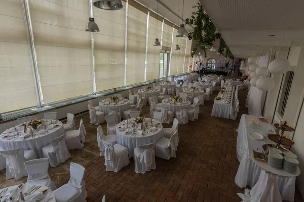 Sarayda bir düğünde yuvarlak masalar ve sandalyeler.