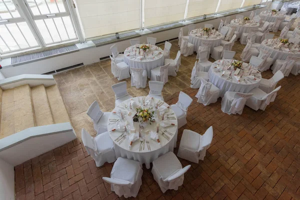 Yuvarlak tablolar ve yukarıdan beyaz dekorasyon görünümü