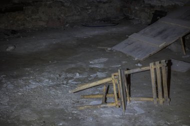 Kale mahzeninde kırık, tahta bir sandalye.