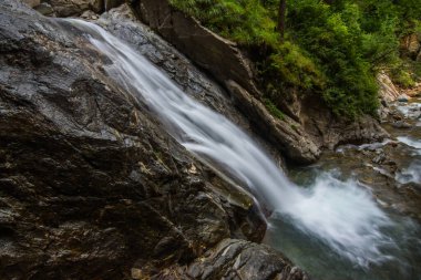 Yüksek ince şelale Yazın bir vadide yürüyüş yaparken