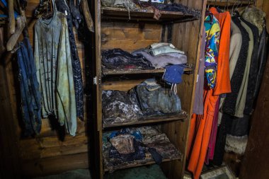 Terk edilmiş bir evde bir avcıdan alınmış dolap ve küflü giysiler.
