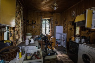 Ormandaki terk edilmiş bir evde bir sürü eşyayla mutfak.