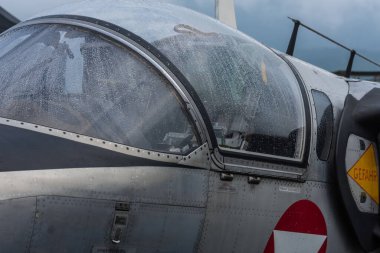 Dağlardaki bir hava gösterisinde üzerinde yağmur damlaları olan bir uçaktan kokpit.