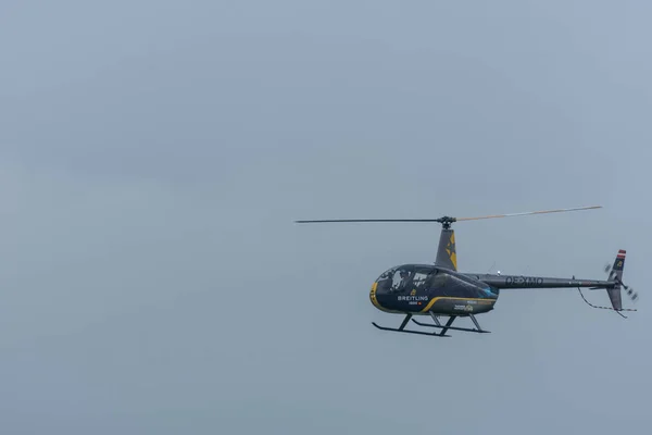 航空ショーで灰色と黄色のヘリコプターを飛んで — ストック写真