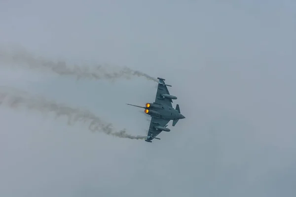 灰色の空の航空ショーで翼に煙と戦闘機 — ストック写真