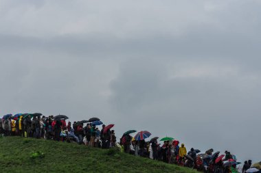 Yazın bir hava gösterisi sırasında şemsiyeli bir sürü insan