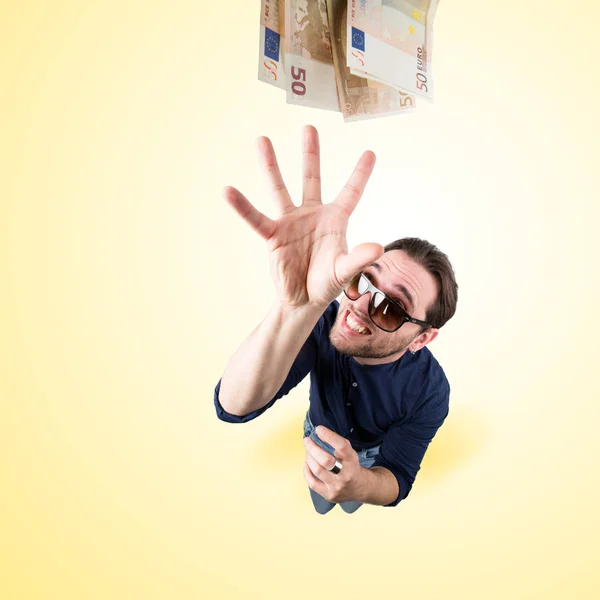 Funny man catch money from above with sun glasses