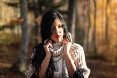 Sonbahar ormanındaki genç bir kadının profil portresi.