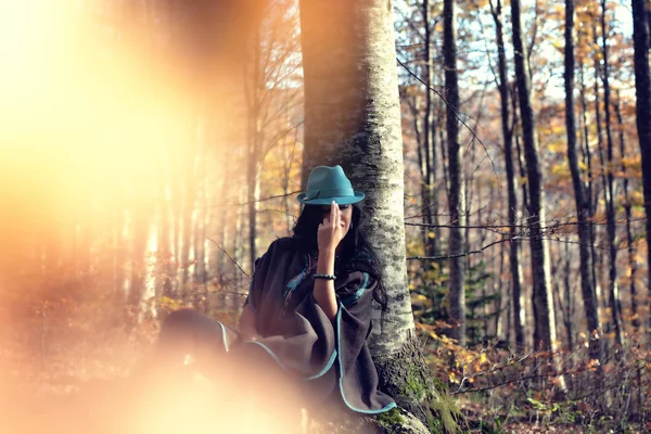 ロビン フッドのように座っている森の中の若い女性の創造的な肖像 — ストック写真