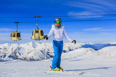 Kız karda güneşli bir günde dağlarda kayak üzerinde. Kayak Kış seasonon, güneşli gün karlı dağların başında. Meribel resort, 3 vallees, Fransa.