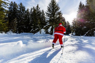 Noel Baba Noel giysileri ile klasik nordic Kayak karlı kış dağ kayak resort peyzaj içinde güneşli gün, yılbaşı ya da xmas ile geliyor.