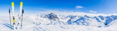 Ski in winter season, mountains and ski touring equipments on the top in sunny day in France, Alps above the clouds clipart