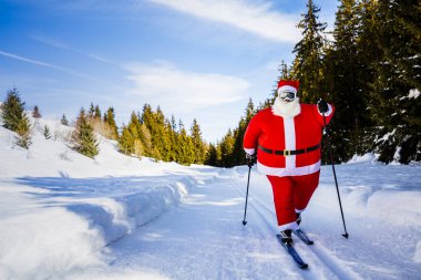 Noel Baba Noel giysileri ile klasik nordic Kayak karlı kış dağ kayak resort peyzaj içinde güneşli gün, yılbaşı ya da xmas ile geliyor.