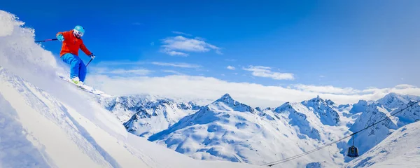 Ski in winter season, mountains and ski touring man on the top in sunny day in France, Alps above the clouds