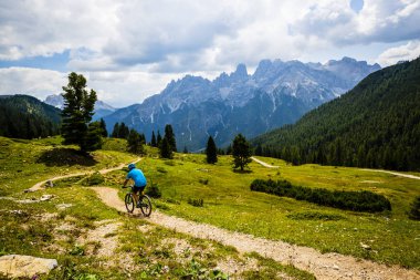 Rocky Dağları arka plan üzerinde çarpıcı turist Cortina d'Ampezzo, Bisiklete binme. MTB enduro akışı iz kişini. South Tyrol İtalya il, Dolomites.
