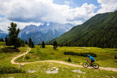 Rocky Dağları arka plan üzerinde çarpıcı turist Cortina d'Ampezzo, Bisiklete binme. MTB enduro akışı iz kişini. South Tyrol İtalya il, Dolomites.