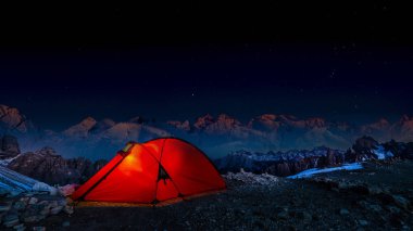 Dağları, milyon yıldızlı gece gökyüzü, kırmızı ışıklı çadır Alpleri'nde geçişte altında nda gece bivouac.