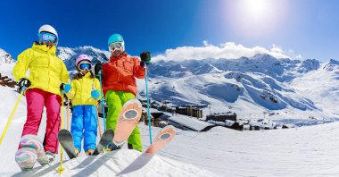 Mutlu bir aile dağlarda kış tatilinin tadını çıkarıyor Val Thorens, 3 vadi, Fransa. Yüksek dağlarda kar ve güneşle oynamak. Kış tatili.