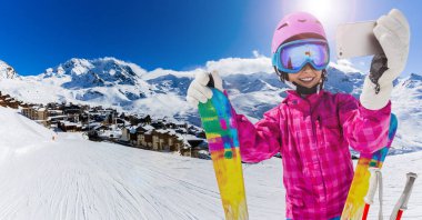 Genç bir selfie, bir kendi kendine portre ile hareket eden telefon, alarak kız alarak Spor Kayak sahip eğlenceli kış tatil.