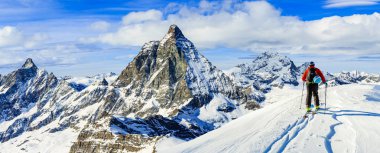 Taze toz karda kayak adam. Karlı dağların tepesinde kış sezonu, dağlar ve Tur kayağı backcountry aletleri ile arka planda Matterhorn, İsviçre Alpleri'nde Zermatt güneşli gün Kayak.