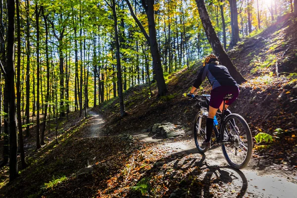 Cycling woman riding on bike in summer mountains forest landscape. Woman cycling MTB flow trail track. Outdoor sport activity.