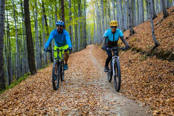 サイクリング サイクル上の山のバイカー カップルは秋の森のトレイルします 秋の風景森で自転車に乗る山 男と女の Mtb 流れ上り坂道をサイクリング — ストック写真