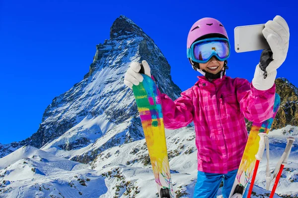 Selfie 携帯電話とのセルフ ポートレートを取る女の子を取ってスポーツ スキーを持つ背景 ツェルマットのマッターホルンと冬休みに楽しい — ストック写真