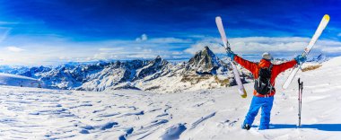 Arka planda Matterhorn, İsviçre Alplerinde Zermatt ile taze toz karda kayak yapan adam..